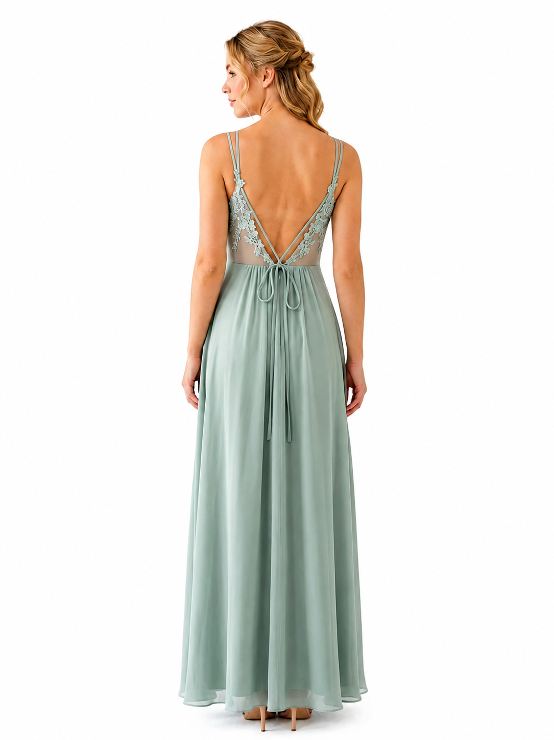 A woman viewed from the back wearing a floor-length sage green dress with thin straps, a lace-up open back, and sheer lace detailing at the neckline.