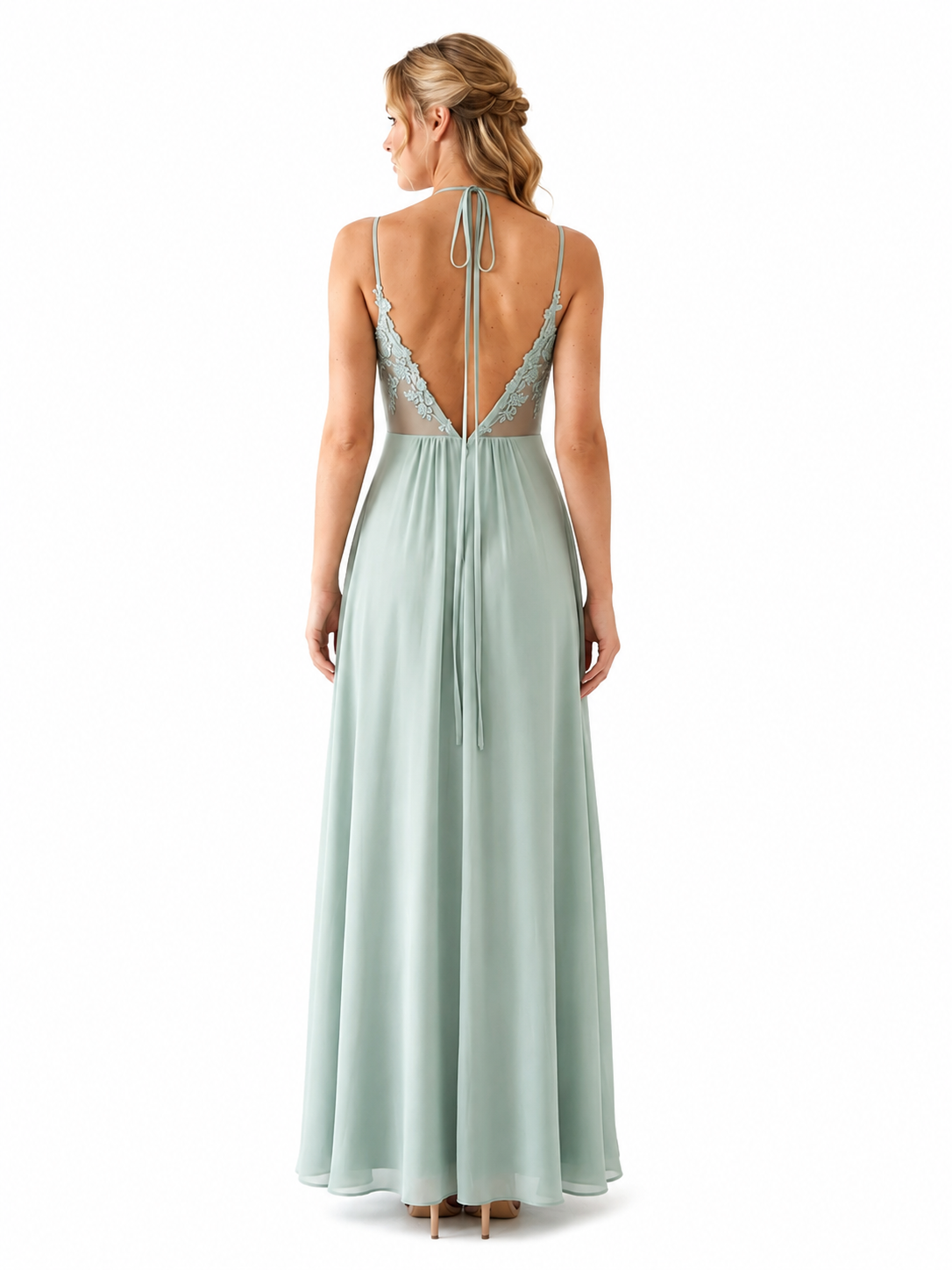 A woman shown from the back wearing a floor-length mint green dress with thin straps, lace trim at the open back, and a tie closure at the waist, photographed against a plain white studio background.