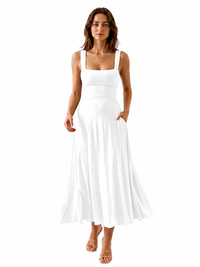 A woman modeling a white sleeveless maxi dress with a square neckline, wide shoulder straps, a fitted waistband, and side pockets, paired with tan heeled sandals against a plain white background.